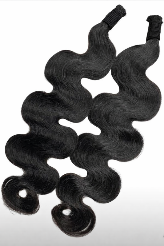 Two bundles of black wavy hair extensions on a white background